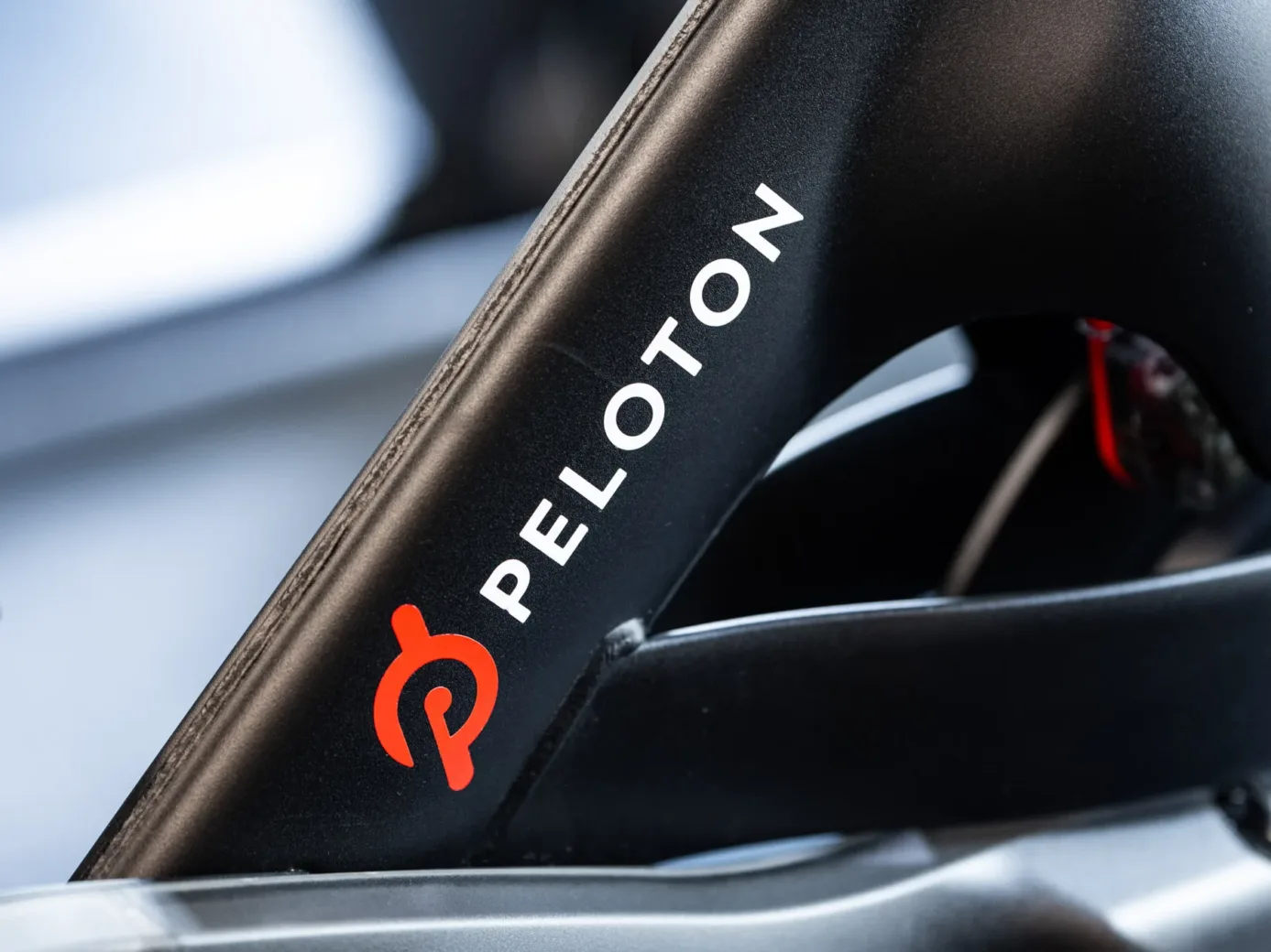 Close-up of a Peloton exercise bike, featuring the brand's logo on a part of the frame.